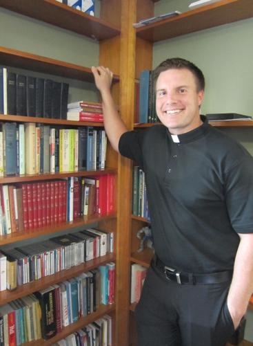 New associate pastor standing near books