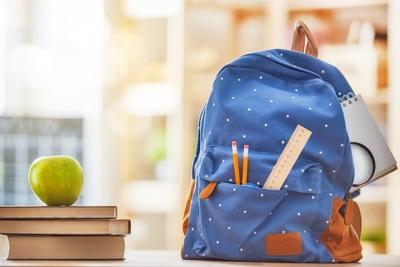 Apple, pile of books and backpack