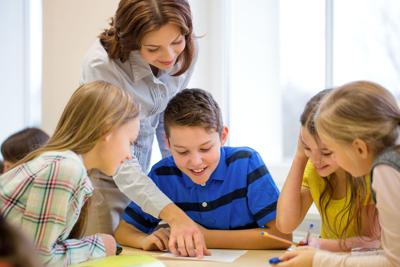 group of school kids writing test in classroom