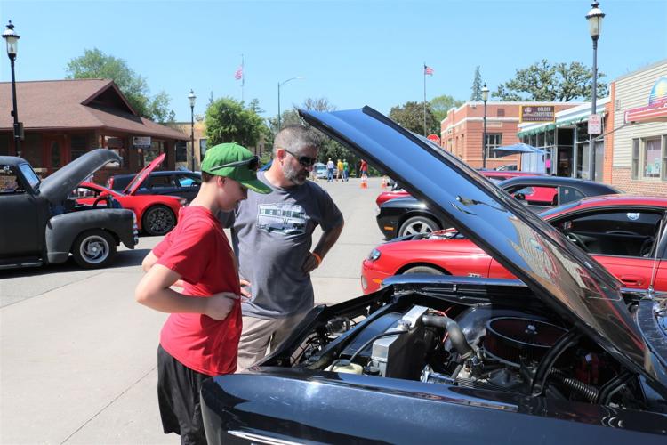 Onlookers view a 1966 Chevy Impala owned by Craig and Stacey Peterson at Forest City Motor Night..JPG