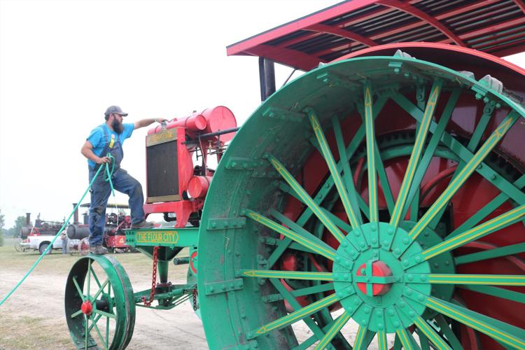 Tyler Kester of Illinois checks on a large, antique prairie tractor at the Heritage Park Steam Threshing Festival..JPG
