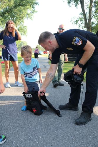 Police officer Aaron Kelso helped Ari Bartleson, 5, at National Night Out..JPG