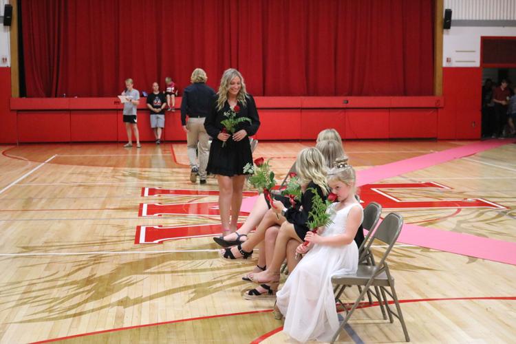 Maddie Bruggeman prepares to be seated with the other homecoming queen candidates while Homecoming Princess Everly Wilson smells her flower..JPG