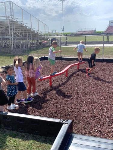West Hancock Elementary students eagerly await their turn on a new curved balance beam.