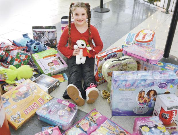 Girl gladly gives gifts to Toys for Tots