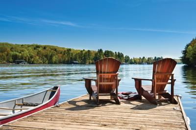 Lakeside scene of a canoe floating by a dock