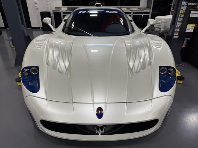 A Maserati MC12 is showcased inside DuPont Registry’s Naples-area showroom, highlighting the high-end and rare vehicles featured at the newly opened luxury auto facility.