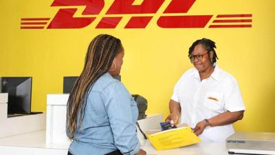 DHL employee assists customer at shipping service counter