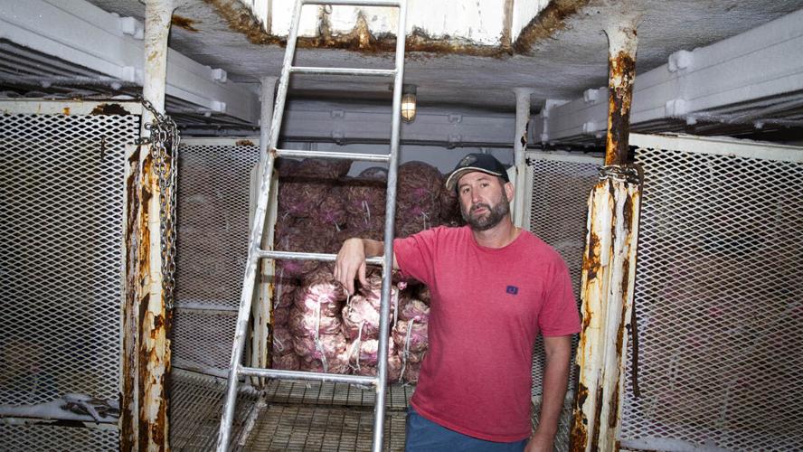 Michael Frost stands with a Gulf pink shrimp haul