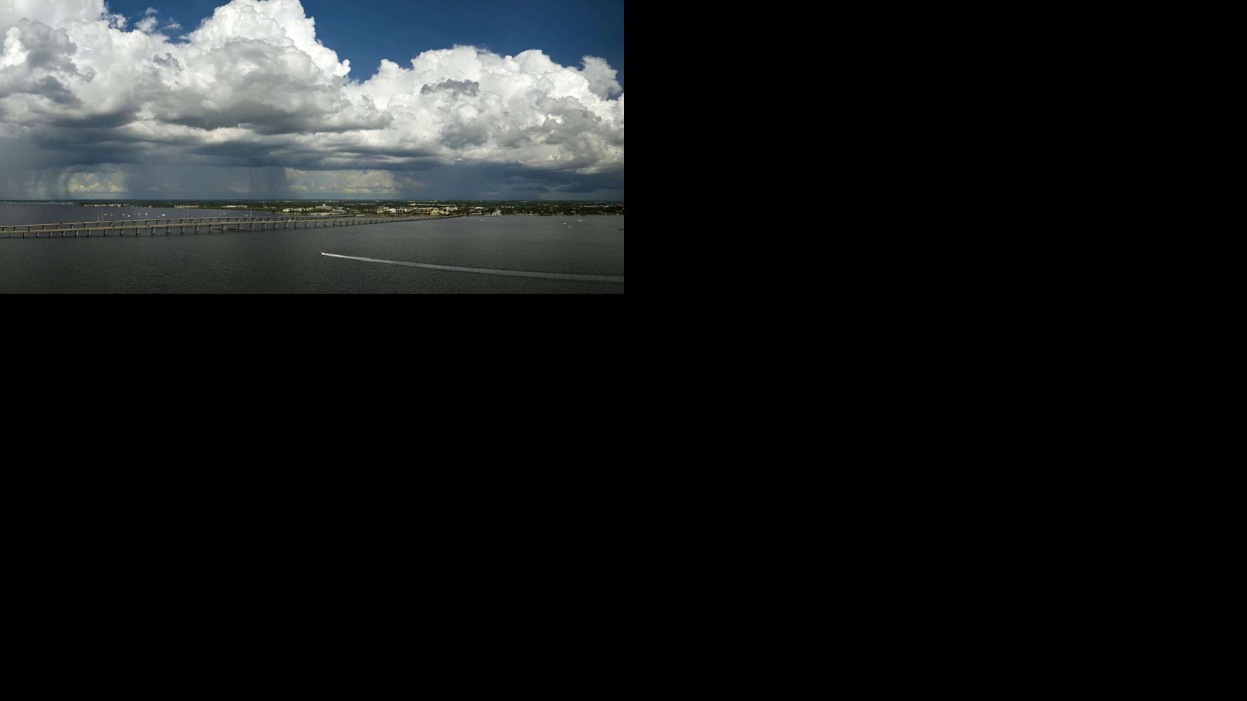 Heavy thunderstorm approaching traffic bridge connecting Punta Gorda and Port Charlotte over Peace River. Bad weather conditions for driving during rainy season in Florida