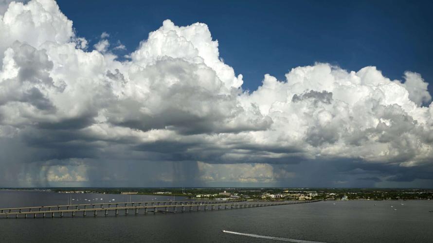 Heavy thunderstorm approaching traffic bridge connecting Punta Gorda and Port Charlotte over Peace River. Bad weather conditions for driving during rainy season in Florida