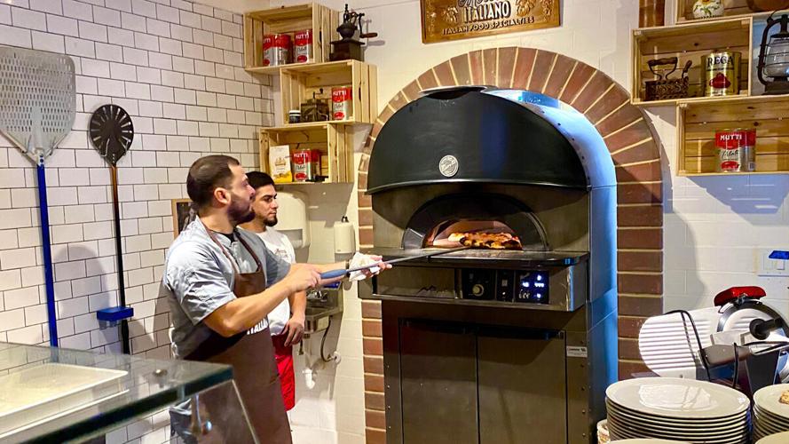 Pizza goes into the oven at La Pizzeria