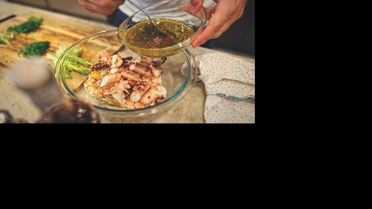 Pouring dressing over seafood