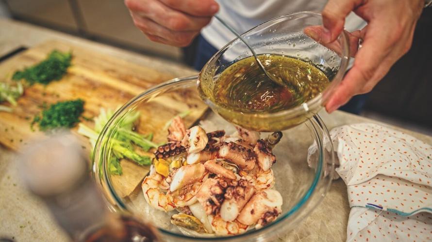 Pouring dressing over seafood