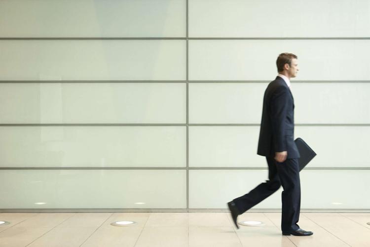 Businessman Striding Down Office Corridor