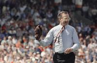 President George H.W.Bush reacts after throwing a one-hopper, the  ceremonial first pitch, to Baltimore Orioles catcher Chris Hoiles to open  Oriole Park at Camden Yards in Baltimore on Monday, April 6, 1992.