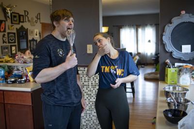 Olympic hopeful wrestler Joe Rau bakes a chocolate marble cake at home with his girlfriend, Astrid De Leeuw, on March 19, 2020 in Des Plaines, Ill.