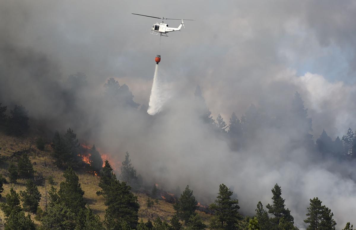 A DNRC helicopter drops water on a wildland fire that sparked Wednesday afternoon