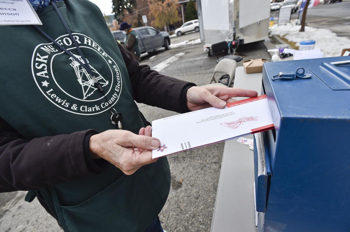 Poll worker Rebecca Johnson drops a ballot in the box