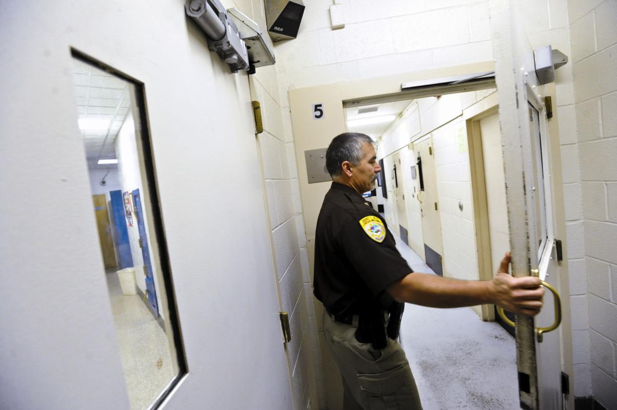 Capt. Alan Hughes passes through a door at the Lewis and Clark County Detention Center.