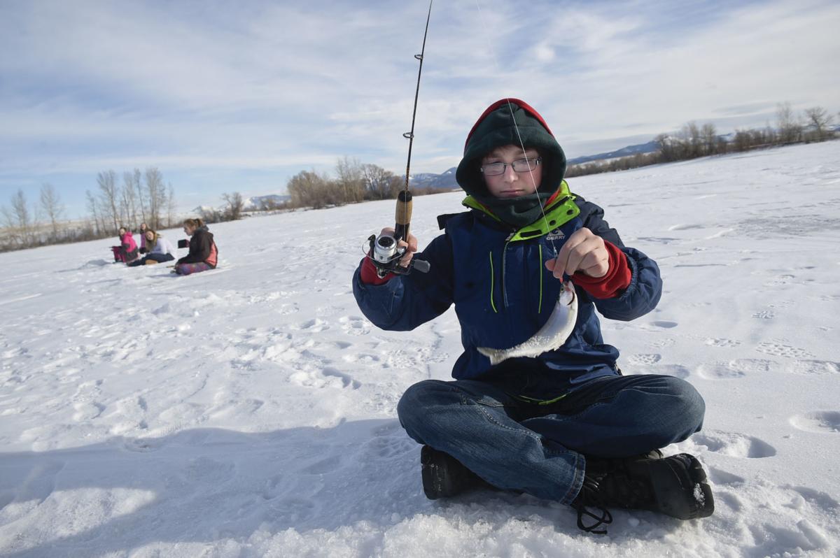 East Valley Middle School student Derek Price grips a kokanee salmon Thursday morning at the Helena Valley Regulating Resevoir.