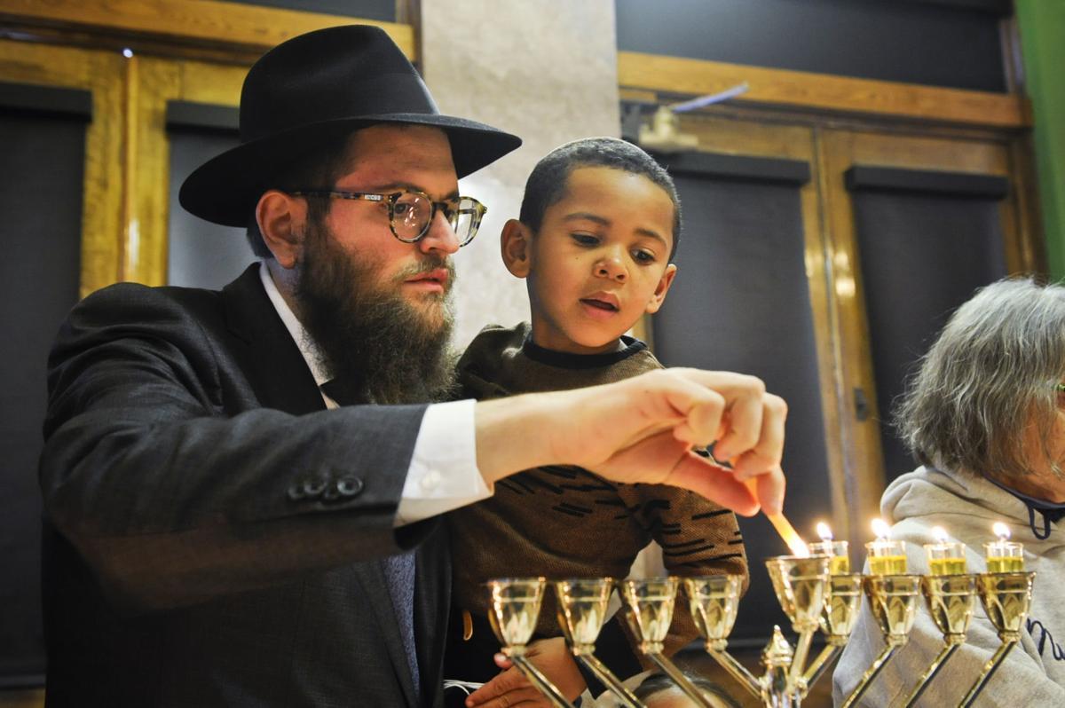 Rabbi Chaim Bruk and his son Menny Bruk light a menorah