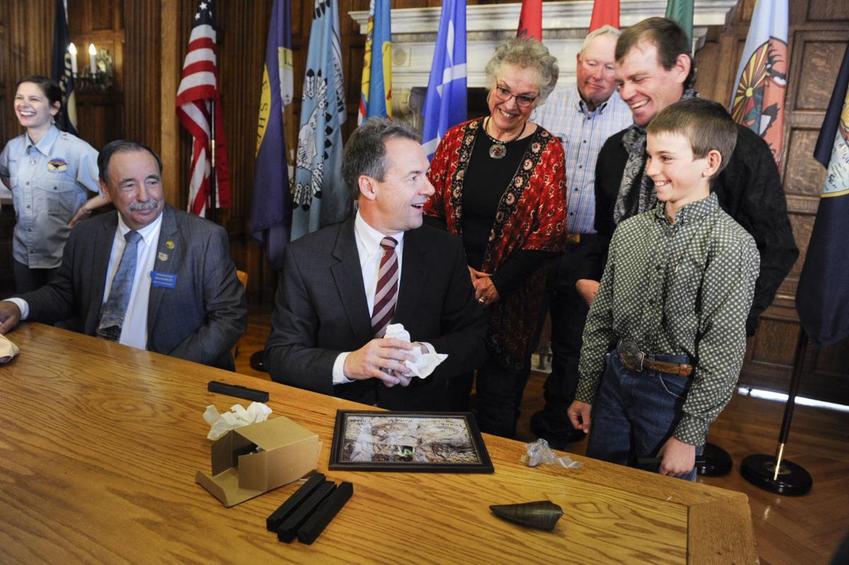 Luke Phipps, 12, right, gives Gov. Steve Bullock