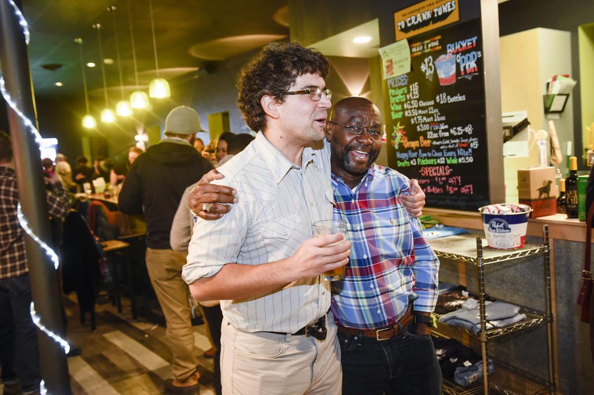 Wilmot Collins, right, and Andres Halladay, left, rejoice after election results were announced Tuesday night.