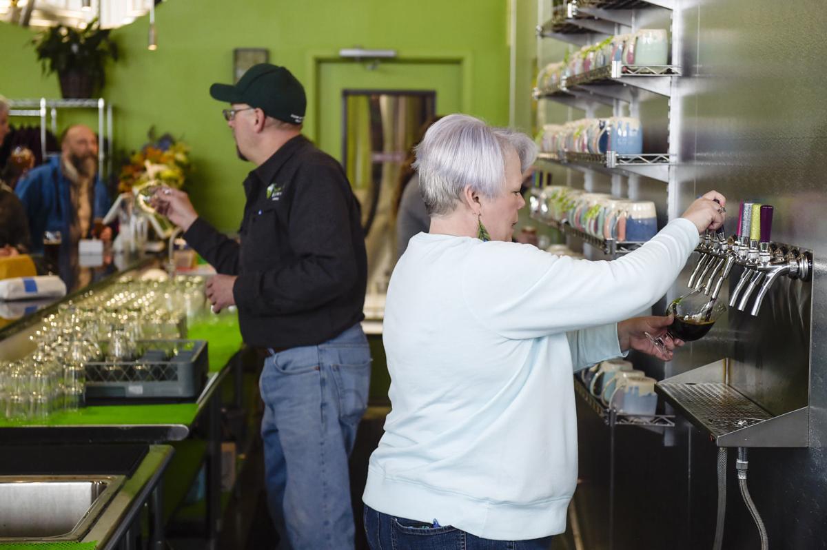 Owner Barbie Edwards, right, and Steve Edwards serve beers Friday afternoon at Snow Hop Brewery.