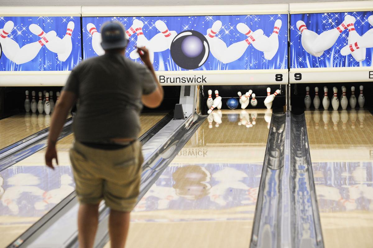 A bowler bowls a strike at Sleeping Giants Lanes bowling alley a