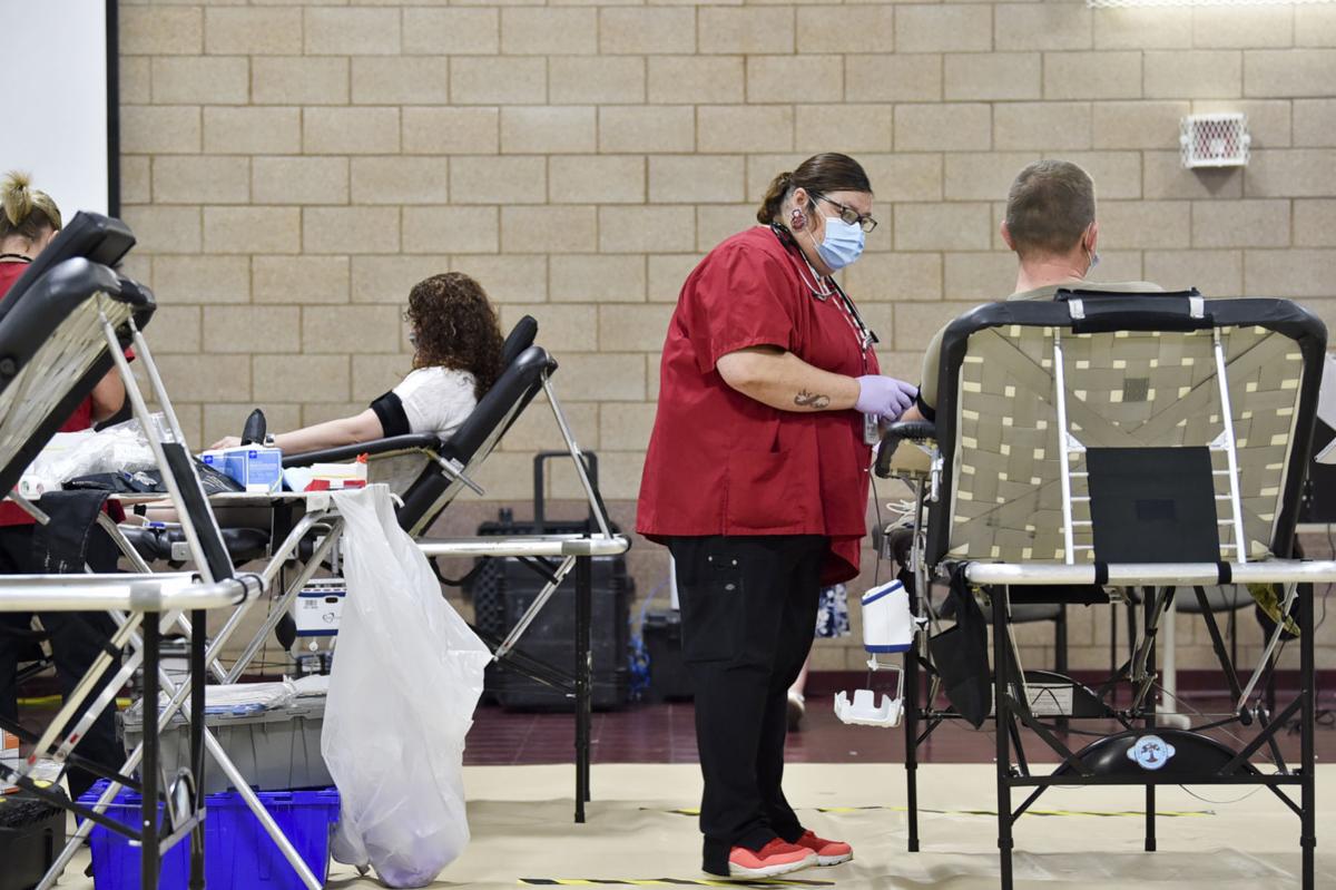 Adrienne Loves, center, draws blood from MSGT Michael Touchette on Wednesday at a Red Cross blood drive on Fort Harrison.
