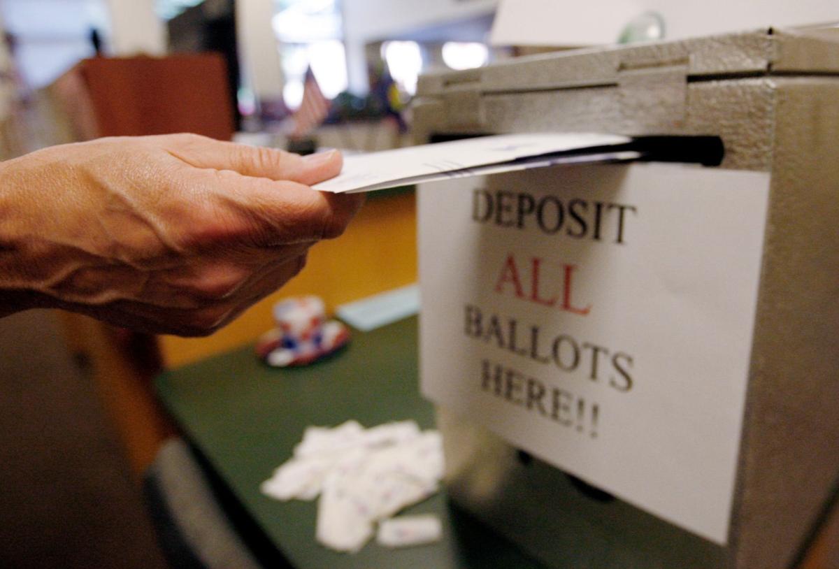A voter drops their ballot off