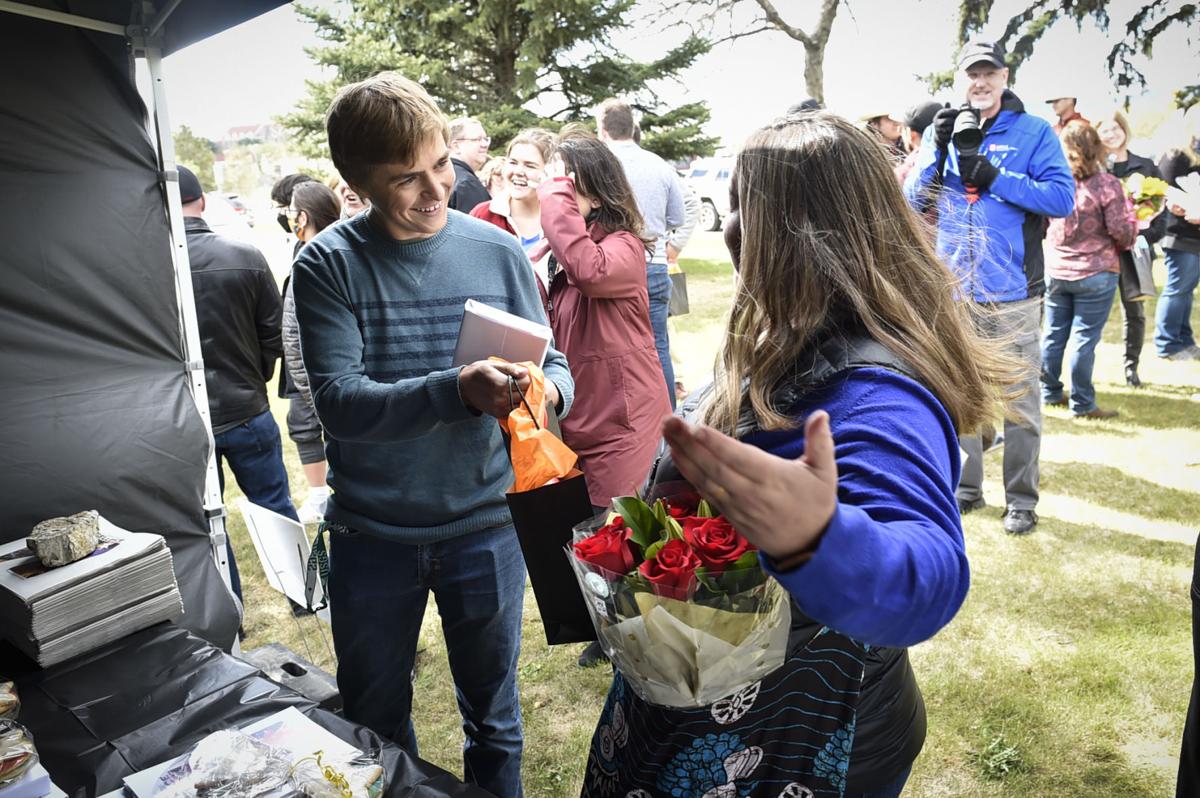 Helena High School student Heath Caldwell hands his teacher, Claire Pichette,