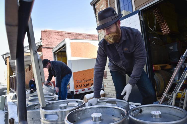 Gulch Distillers co-owner Tyrell Hibbard helps unload 30 unused kegs of beer