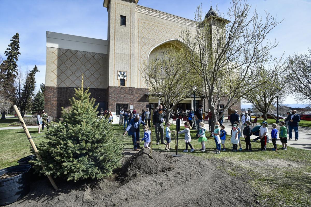 Helena Mayor Wilmot Collins assists some children with the planting