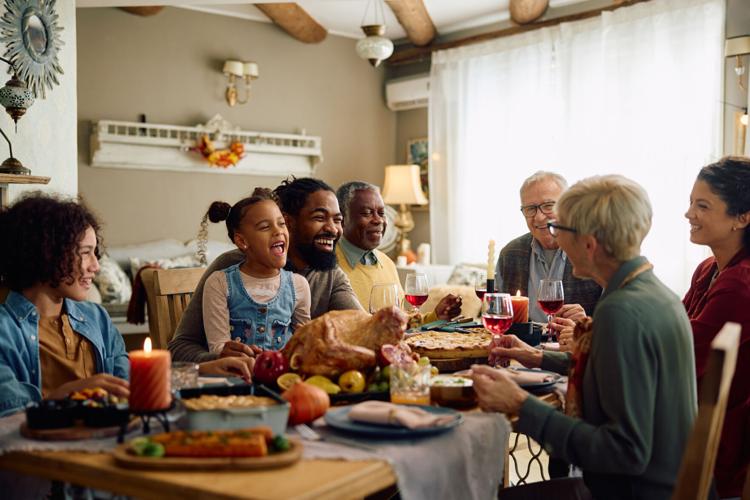 Happy extended family having fun while gathering at dining table on Thanksgiving.