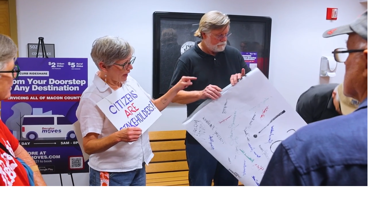 Illinois People's Action delivers banner to Macon County Board offices