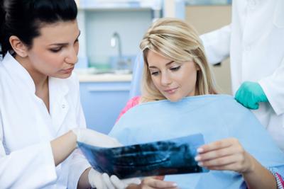 dentist showing female patient dental X-rays
