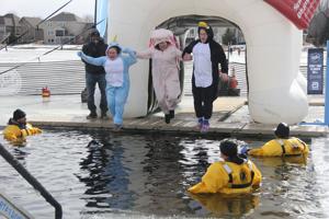 Other Text Three participants in onesies plunge into the freezing depths at the Anoka County Polar Plunge at Lakeside Commons Park on Saturday, Feb. 28. Alt Text