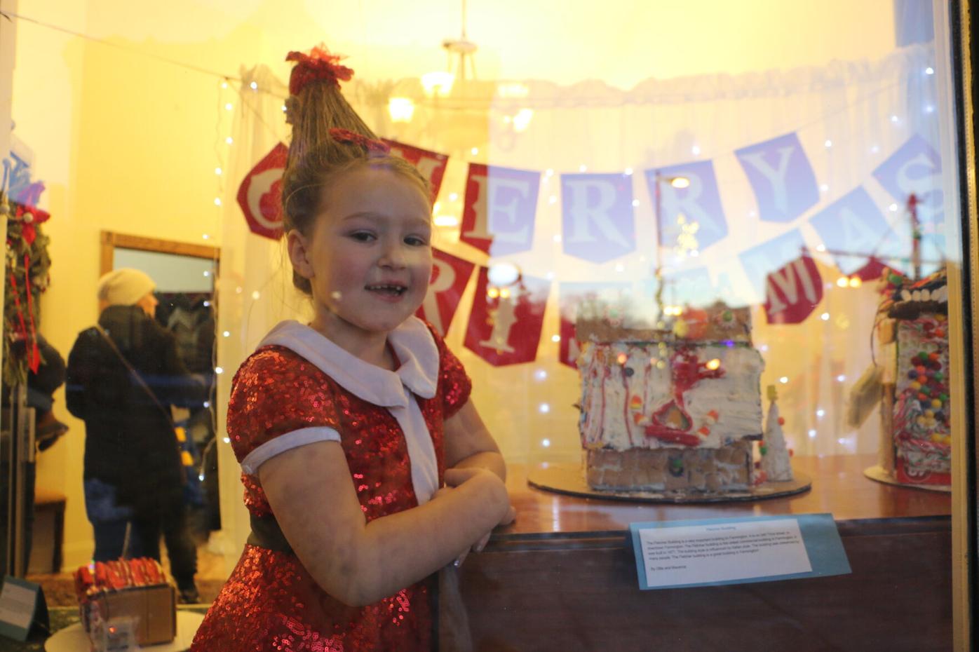 Children decorate gingerbread houses in store windows