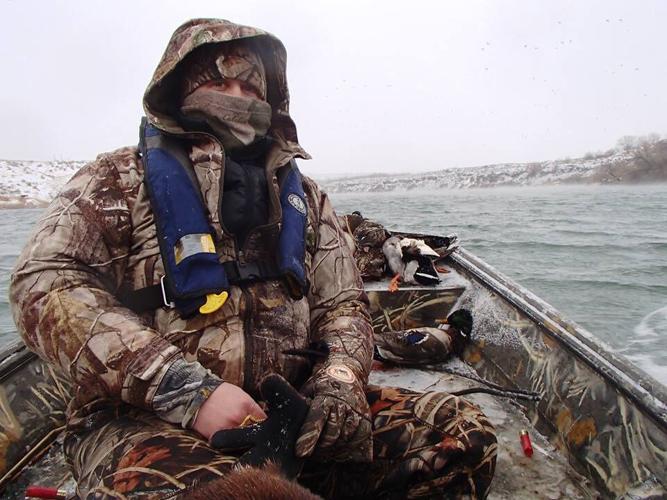 Duck hunter in icy boat