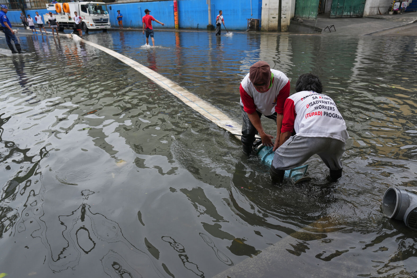 Intense monsoon rains cause severe flooding in Quezon City, Metro Manila, Philippines as workers pump out flood waters.