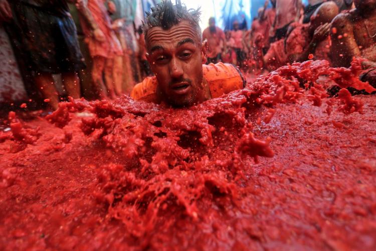 Photos show revelers pelting one another with tomatoes at Spain’s La Tomatina food fight