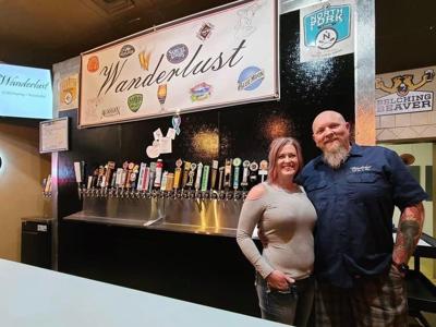New owners Jenifer and Kevin Busick in front of their 36 beer tap
