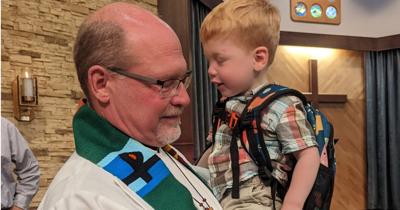 Pastor Jonathan Dinger holding his grandson