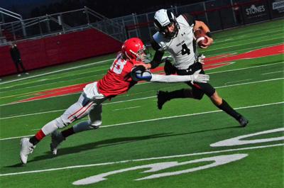 Highland's Easton Durham tries to run an end-sweep by Madison's Josh Jones who tackles him for a short gain in Highlands win over the Bobcats Friday night.