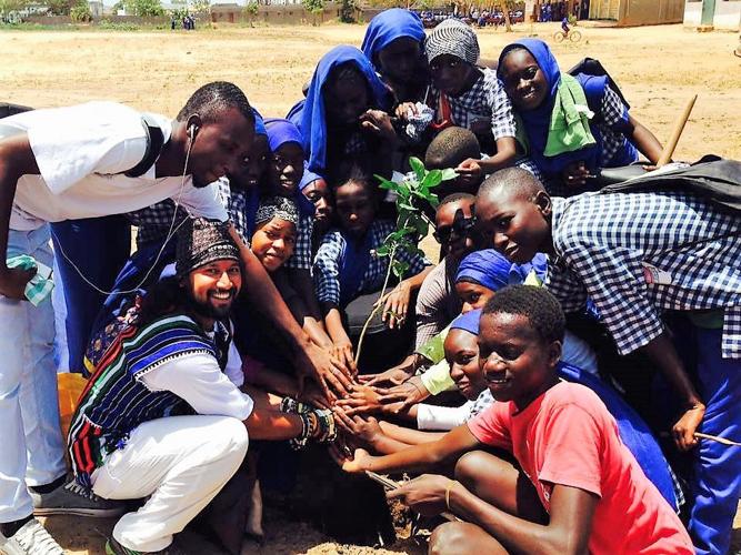 Somen Debnath poses next to planted tree in Africa