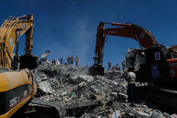 Photos show rescuers recovering bodies after strike-damaged building collapses in Gaza