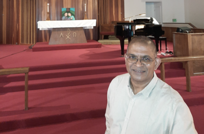 Pastor Deepak Babu stands inside Pocatello First United Methodist Church