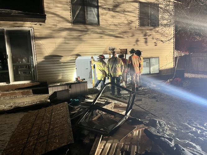 Firefighters outside hole in house made by car